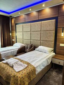 a hotel room with two beds and a couch at Hotel Diamant in Dospat