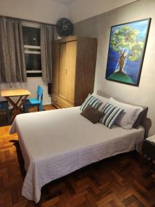 里約熱內盧的住宿－Loft Copacabana，卧室配有一张大床,墙上挂有绘画作品