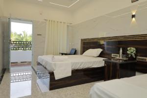 a hotel room with a large bed and a balcony at HOTEL CYRIL in Kanyakumari