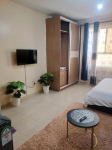 Un dormitorio con una cama y una mesa en una habitación. en City view suits, en Nairobi 8 fotos más