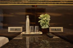 - une table avec une bouteille et deux verres dans l'établissement HOTEL CYRIL, à Kânyâkumârî