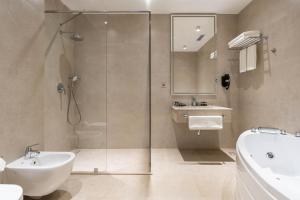 a bathroom with a glass shower and a sink at FrankFort Expo Hotel in Tashkent