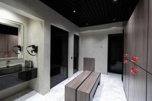 La salle de bains est pourvue d'un banc en bois et d'un lavabo. dans l'établissement FrankFort Expo Hotel, à Tachkent