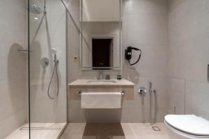 a bathroom with a shower and a sink and a toilet at FrankFort Expo Hotel in Tashkent