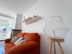 a orange couch in a living room with a lamp at Luminoso Apartamento a 4 min del Museo Dalí - Caserna 13 in Figueres