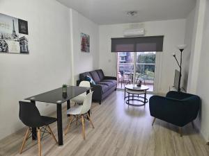 a living room with a table and chairs and a couch at Takelena Apartments in Limassol