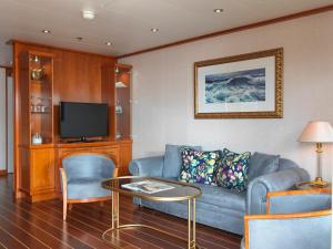 a living room with a couch and a tv at Sunborn London Yacht Hotel in London