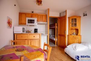 豐羅穆的住宿－L'églantine，一间带桌子和微波炉的小厨房