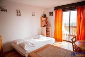 豐羅穆的住宿－L'églantine，一间卧室设有一张床和一个阳台的窗户。