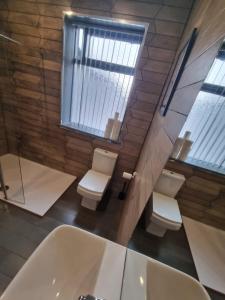 a bathroom with two toilets and a bath tub at Sussex Apartments 26B in Grimsby