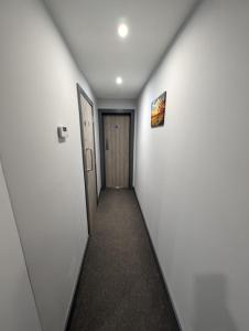a hallway with white walls and a door at Sussex Apartments 26B in Grimsby