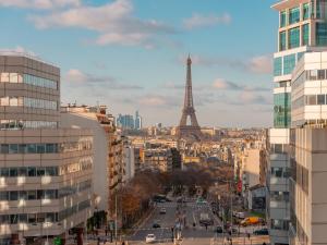 eine Stadt mit dem Eiffelturm im Hintergrund in der Unterkunft Mercure Paris Gare Montparnasse TGV in Paris