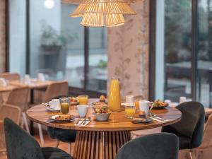 - une table avec de la nourriture et des boissons dans un restaurant dans l'établissement Mercure Paris Gare Montparnasse TGV, à Paris