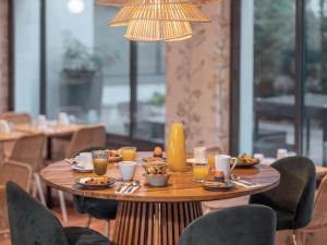 a table with food and drinks on it in a restaurant at Mercure Paris Gare Montparnasse TGV in Paris