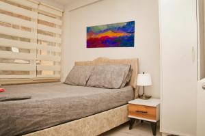 1 dormitorio con 1 cama y una pintura en la pared en Balıkesir Suit, en Balıkesir