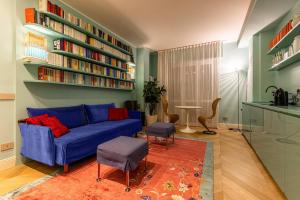 a living room with a blue couch and bookshelves at Verde Acqua - Design & Comfort in Milan