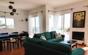 ein Wohnzimmer mit einem grünen Sofa und einem Tisch in der Unterkunft Selecta Casa Blanca Estepona in Estepona