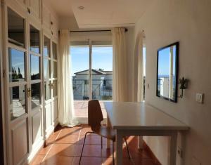 ein Esszimmer mit einem Tisch und einem Balkon in der Unterkunft Selecta Casa Blanca Estepona in Estepona