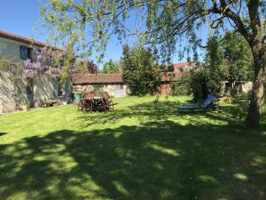 CersayにあるMaison de charme à la campagneのピクニックテーブルと木のある庭