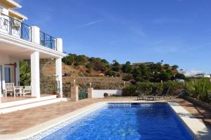 eine Villa mit einem Pool vor einem Haus in der Unterkunft Selecta Casa Blanca Estepona in Estepona