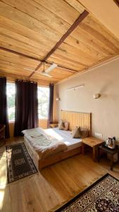 帕拉姆普爾的住宿－Aalna by Ecostel，一间卧室设有一张带木制天花板的大床