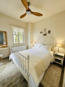 sypialnia z białym łóżkiem i wentylatorem sufitowym w obiekcie Luxury Villa at Pelion- Ruby w mieście Zagora