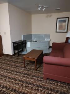 uma sala de estar com um sofá e uma mesa de centro em Days Inn & Suites by Wyndham Fargo 19th Ave/Airport Dome em Fargo