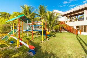 un parque infantil en un patio junto a un edificio en Arraial Ville Residence, en Arraial d'Ajuda