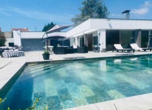 a swimming pool in front of a house at Villa Les Jardins d'Anne-So in Jarny