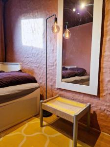 um quarto com uma cama, um espelho e uma mesa em Koselig kjellerleilighet em Bergen