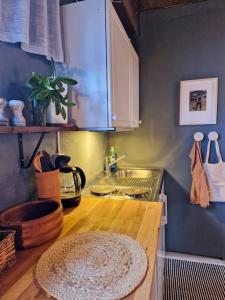 uma cozinha com um lavatório e uma bancada de madeira em Koselig kjellerleilighet em Bergen