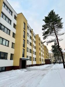 una calle cubierta de nieve frente a un edificio en Уютная квартира в центре, en Klaipėda