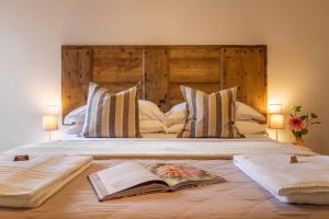 una camera da letto con un grande letto con un libro sopra di Ginevra Home a Monterosi
