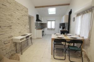a kitchen with a table and chairs in a room at Maison pierre & poutres - 6pers - Orly 10min in Orly