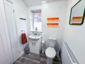 a white bathroom with a toilet and a sink at Vibrant Tranquility: What a gem! in Cleethorpes