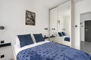 a bedroom with a bed and a mirror at City Center Apartments with GYM & FREE GARAGE Poznań by Renters in Poznań