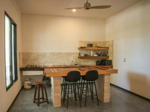 a kitchen with a counter with stools in it at Casa Mate BeachFront HOUSES El Cuyo in El Cuyo