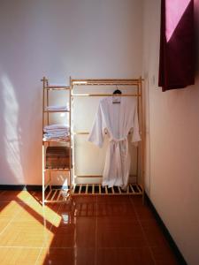 ein weißer Bademantel hängt auf einem Kleiderständer in einem Zimmer in der Unterkunft Casa Mate BeachFront HOUSES El Cuyo in El Cuyo