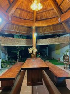 uma grande mesa de madeira num quarto com tecto em The Memory Villa - Mộc Châu em Mộc Châu