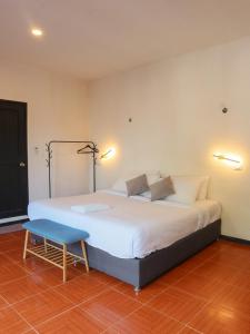 sypialnia z dużym białym łóżkiem i niebieskim stołkiem w obiekcie Casa Mate BeachFront HOUSES El Cuyo w mieście El Cuyo