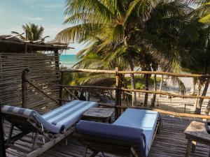 a deck with a bench and chairs on the beach at Casa Mate BeachFront HOUSES El Cuyo in El Cuyo