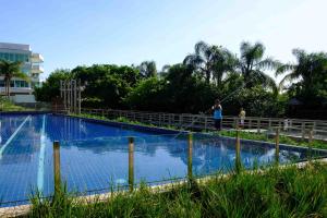 una persona en una cuerda alrededor de una piscina en Apartamento Vista Mar 2 quartos em Condomínio Clube a 100 metros da Praia do Campeche, Florianópolis, en Florianópolis