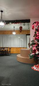 een kamer met een kerstboom en een tafel en stoelen bij АНАСОЛЬ in Slavske