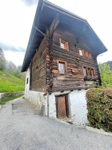 ein altes Holzgebäude mit seitlichen Fenstern in der Unterkunft Cosy mountain apartment 5min walk from Gondola in Fiesch