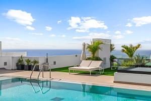 a villa with a swimming pool and the ocean at Palmera Sea View in Patalavaca