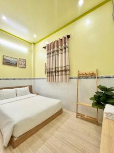 um quarto com uma cama branca e uma janela em ARYE guest house em Ấp Lợi Ðủ