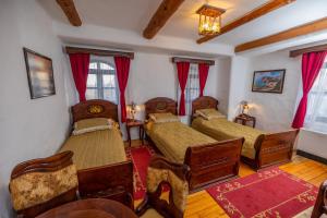 a bedroom with two beds with red curtains at Ethno Village Stanisici in Bijeljina