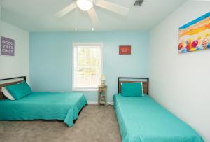 two beds in a room with blue walls at Cresent Beach House by Palmetto Vacation Rentals in Myrtle Beach