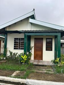 mały biały dom z brązowymi drzwiami w obiekcie Casa Honorio w mieście Pila