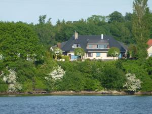 a house on top of a hill next to a lake at Fischreiher 2 in Kappeln